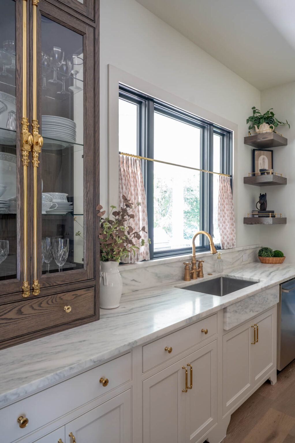 marble countertop with an open window beyond a farm sink.