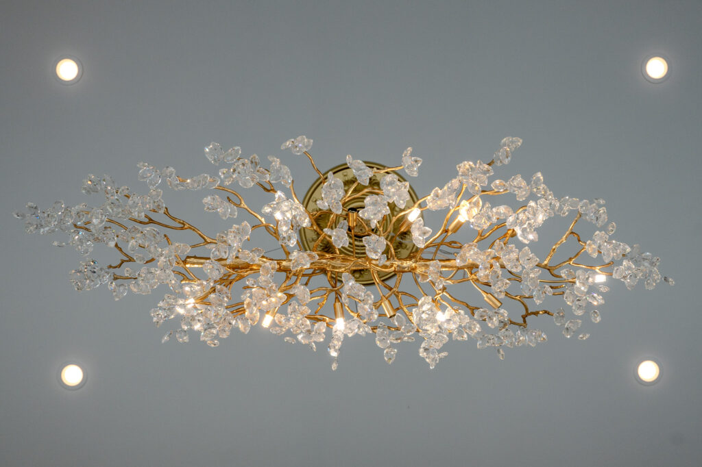 looking up at a large ornate light fixture and can lights surrounding it