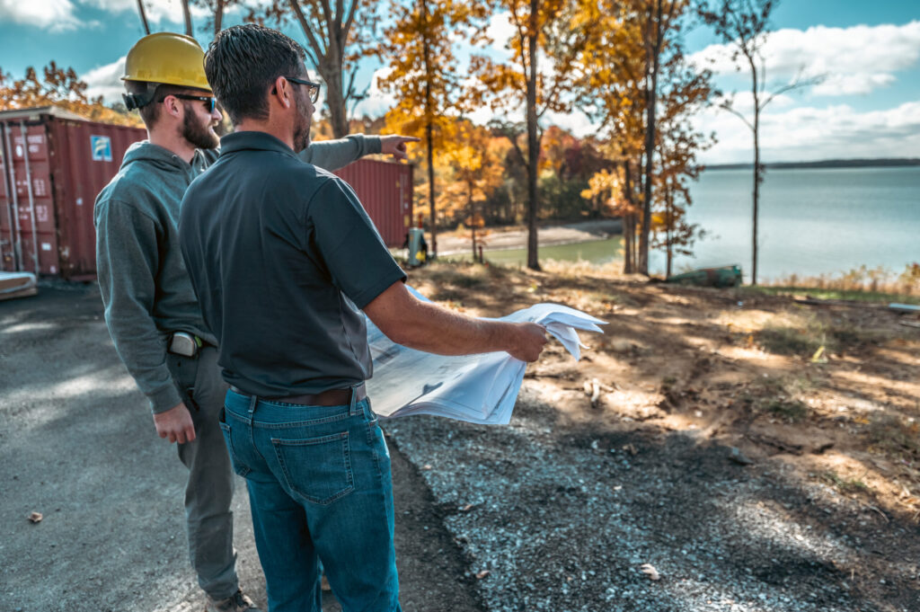 James Mitchell holding blueprints overlooking Kentucky Lake
