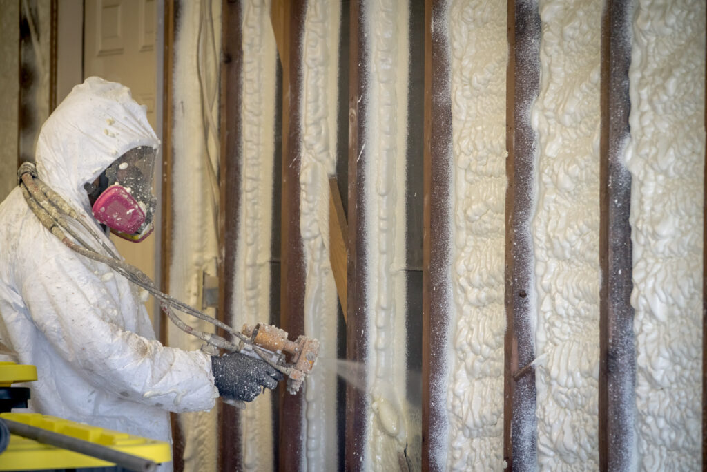 person spraying foam insulation