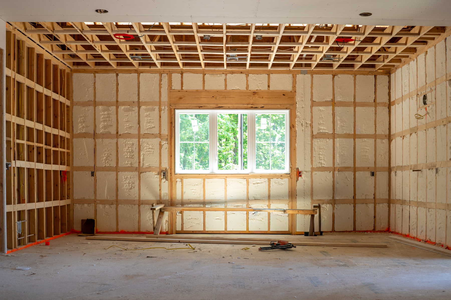 Photo of a kitchen under construction. Foam insulation has been added throughout the walls