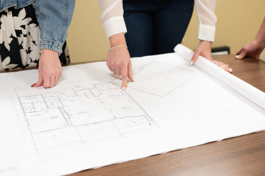 members of the MC Homes design team looking over blueprints